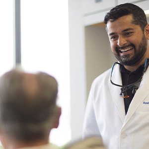 Dentist smiling at patient in treatment room