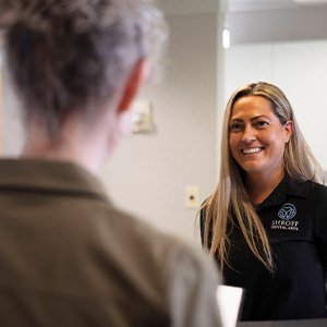 Dental receptionist smiling at patient in lobby
