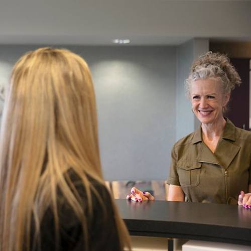Woman in army green shirt checking out at countertop