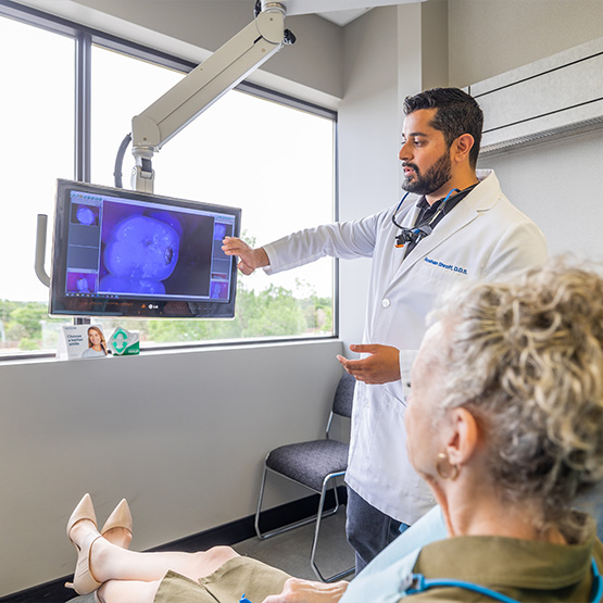Blue gloved hands holding an intraoral camera