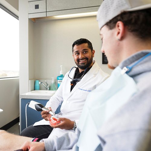 Dentist scanning model teeth to demonstrate digital impressions
