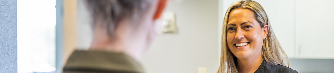 Smiling woman talking on phone to request a dental appointment in Centennial