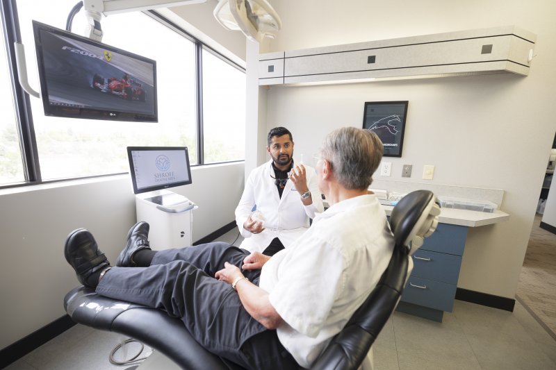 A dentist talking to his patient about a potential treatment