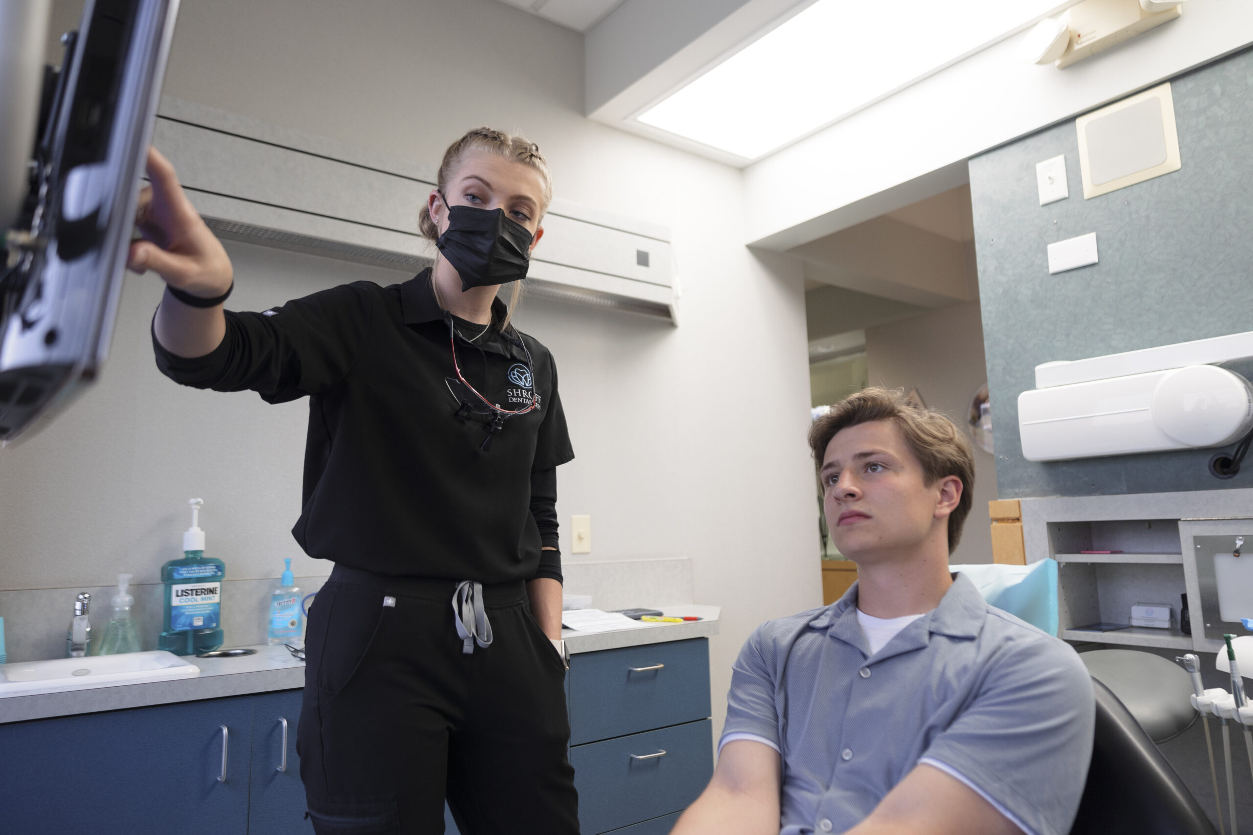 A dental hygienist showing her patient an X-ray