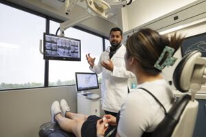 Dentist talking to patient with X-ray in background. 