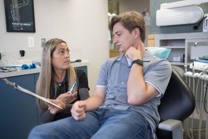 Dentist going over medical history forms with patient